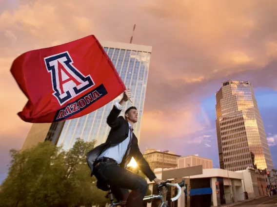 Man on a bicycle waving UA Flag